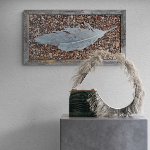 Tableau d'une plume d'oiseau en situation audessus d'un meuble