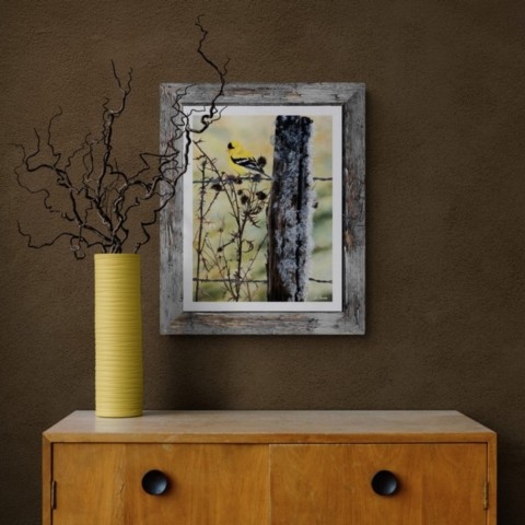 Tableau d 'un oiseau jaune en situation au dessus d'une commode