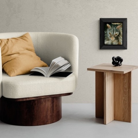 Common genet portrait painting wall art decor next to an armchair by wildlife artist Laurence Saunois